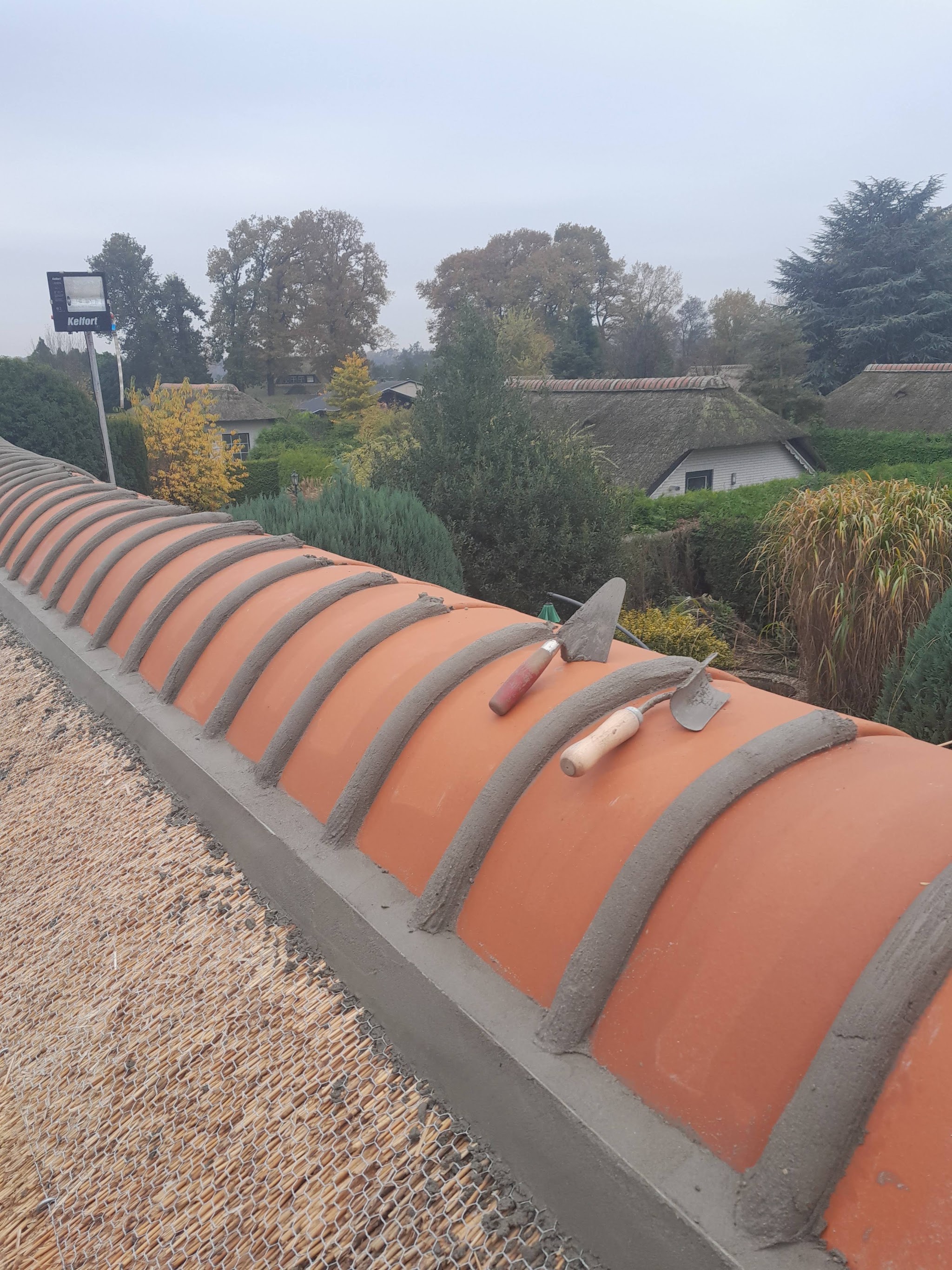 De vorst met oranje vorstpannen in de specie, met gereedschap erop